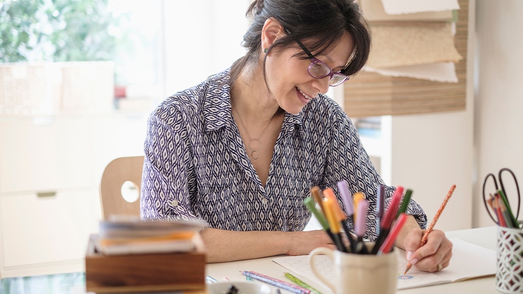 Latin woman drawing at desk